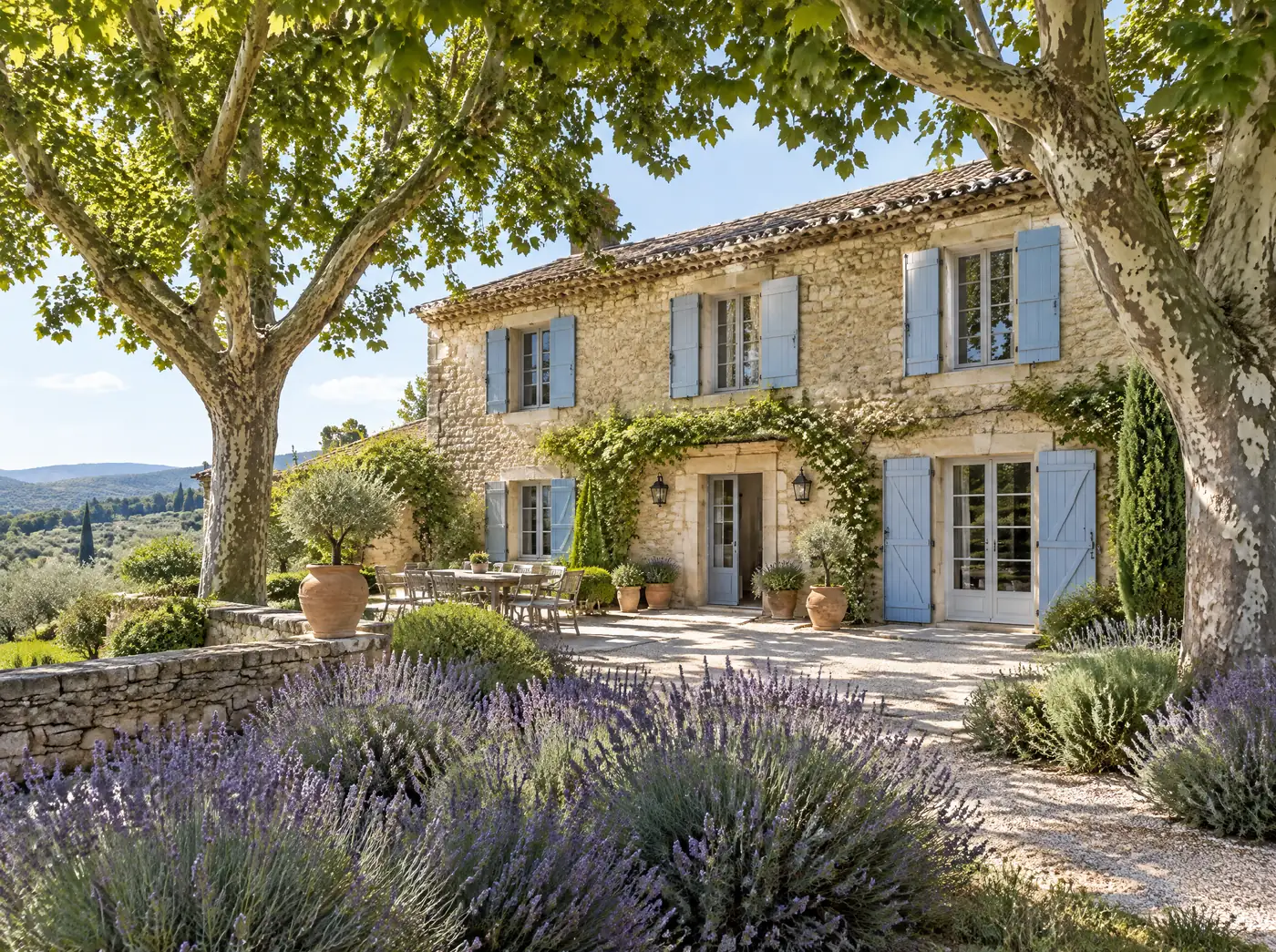 Bastide en pierre aux volets bleus, platanes et massifs de lavande